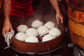 Young man cooking chinese traditional steamed buns at the street food stall in Chinatown - PhotoDune Item for Sale