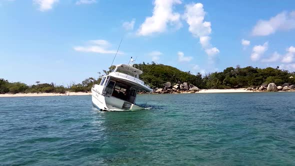Ship wreck crashed in shallow tropical waters with island in background.