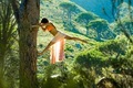 Woman hanging on a tree in nature with mountain in the background. - PhotoDune Item for Sale
