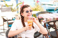 Smiley teenager girl in a simple shirt holding glass of orange juice  - PhotoDune Item for Sale