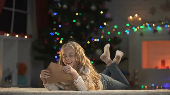 Adorable Kid Kissing Envelope With Letter for Santa, Waiting for X-Mas Present