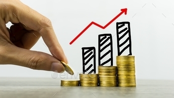 t concepts. A business man putting coin on stack of coins on a table with growing graph on coins pile. Depicts a standing and stable investment.
