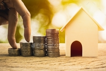 home concepts. House wooden model , Fingers climb on coins. depicts a funding or growing money for real estate investment.