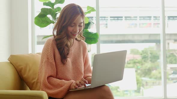 beautiful asian woman Sitting at home working in the living room.