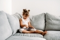 Toddler girl playing with digital wireless tablet computer on couch at home. - PhotoDune Item for Sale