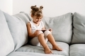 Toddler girl playing with digital wireless tablet computer on couch at home. - PhotoDune Item for Sale