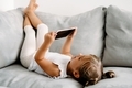 Toddler girl playing with digital wireless tablet computer on couch at home. - PhotoDune Item for Sale