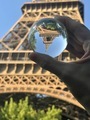 Eiffel Tower reflected in lens ball held by human hand  - PhotoDune Item for Sale
