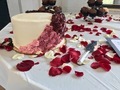 White wedding cake with rose petals scattered on the table  - PhotoDune Item for Sale