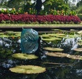 Dale Chihuly glass sculpture floating in a pond with large Lilly pads  - PhotoDune Item for Sale