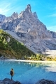 Amazing view of Sorapis lake with traveler girl on the rock looking on the mountain Dolomites Italy - PhotoDune Item for Sale