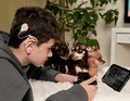 deaf boy with cochlear implant playing computer game on playstation and watching cartoon with dogs - PhotoDune Item for Sale