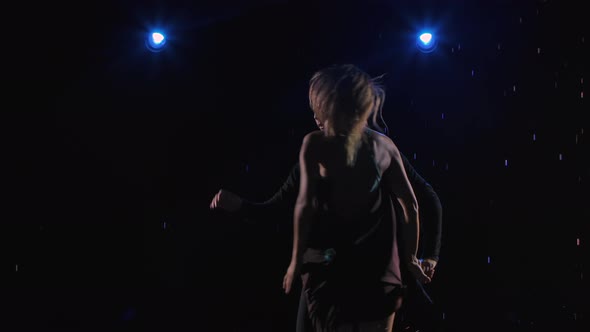 Flexible and Sensual Dancers Dance Ballroom Dancing in a Dark Studio in the Rain