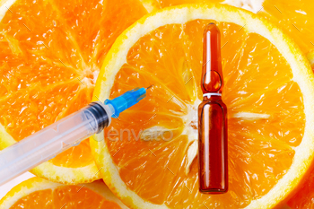 syringe over orange fruits