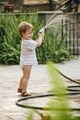 Toddler playing in the backyard with water from a hose - PhotoDune Item for Sale