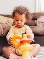 Mixed race curly hair boy at home learning how to stack colorful rings - PhotoDune Item for Sale