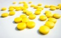 Yellow pills laying on the white background. - PhotoDune Item for Sale