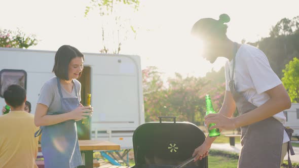 Group of Asian man and woman friend having holiday party outdoor in the evening together in camp.