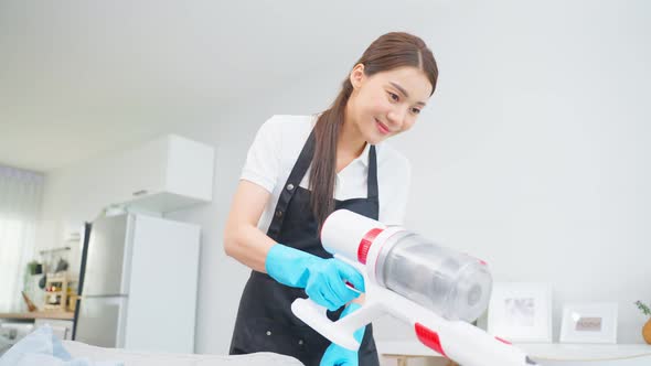 Asian cleaning service woman worker cleaning in living room at home.