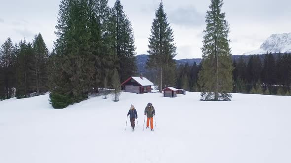 Couple snowshoeing with sibirian husky