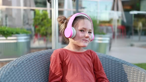 A young girl bobs her head as she listens to her favorite music on her headphones.