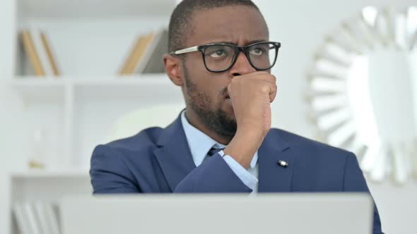 Portrait of Sick African Businessman with Laptop Coughing