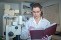 Young woman researcher taking notes in laboratory research  - PhotoDune Item for Sale
