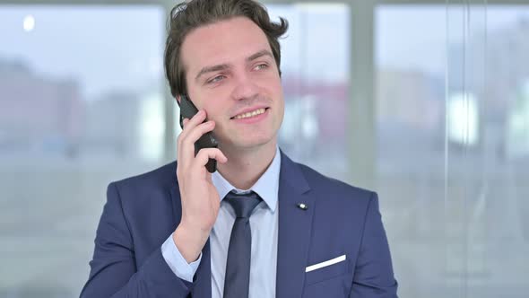 Portrait of Cheerful Young Businessman Talking on Smartphone 