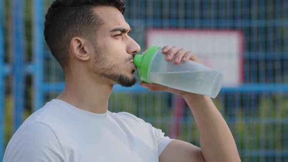 Successful Middle Eastern Indian Man Athlete Latino Runner Holding Drinking From Sport Bottle During