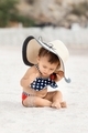 Infant baby girl sitting on sandy beach - PhotoDune Item for Sale