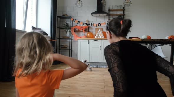 Little Girl with Mother Playing Pumpkin Bowling