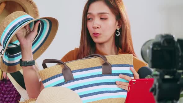 Young Asia girl selling fashion hats and bags on social media by streaming live from her home.