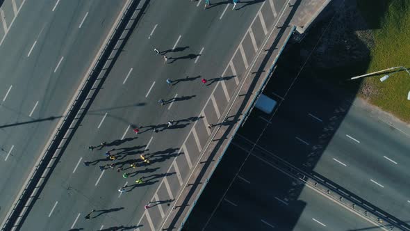 Aerial Drone Fooage. Marathon Running On Road Bridge. Top View