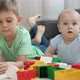 Little Baby Boy with Older Brother Playing Toy Blocks and Bricks on Carpet in Living Room - VideoHive Item for Sale