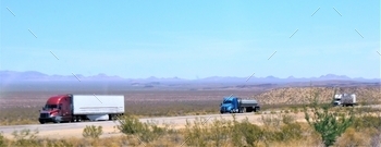 auling enclosed trailers on a long haul on the open road through the rural desert. A third big rig hauls a tanker trailer. Convoy! Gas and Oil!