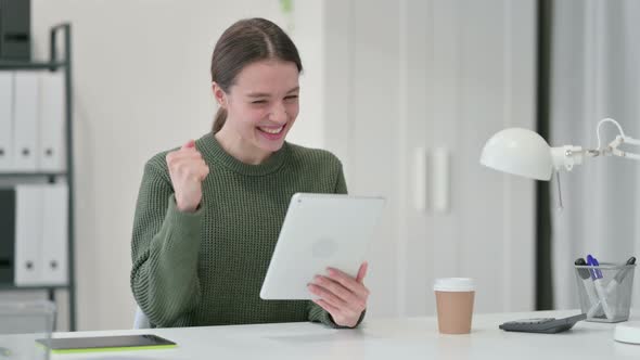 Young Woman with Tablet Celebrating Success 