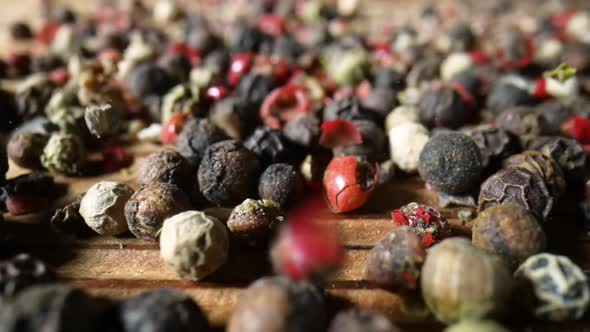 Camera Pans Over Colorful Mix of Hot Peppercorns on the Wooden Kitchen Table