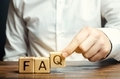 Businessman puts wooden blocks with the word FAQ (frequently asked questions) - PhotoDune Item for Sale