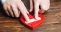 A man sticks together a red heart with a plaster - PhotoDune Item for Sale