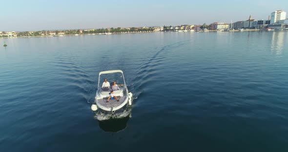 A Drone Shot of a Happy Family on a Summer Vacation Driving a Luxury Boat on the High Seas in the