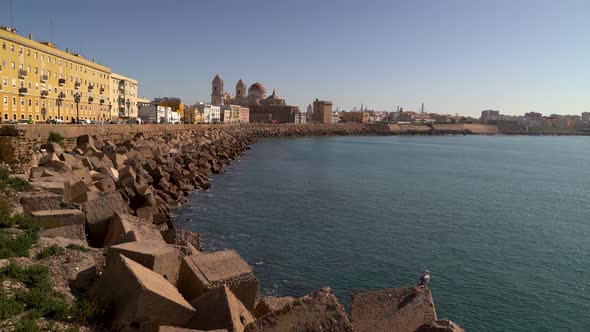 Wide open view toward wave breakers and road in Cadiz, Spain