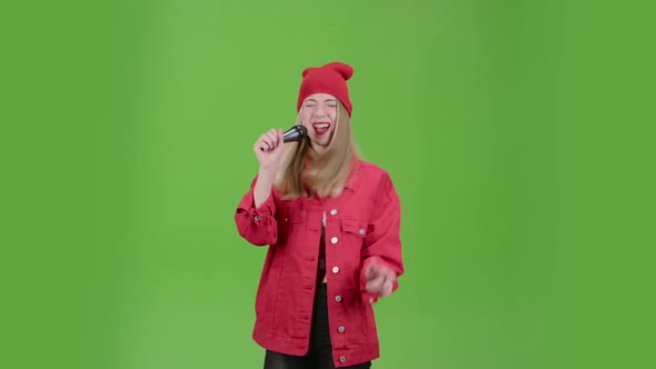 Singer Performs Popular Songs in the Microphone on Stage. Green Screen