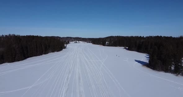 Aerial View of a Frozen Lake in the Forest During Winter Time