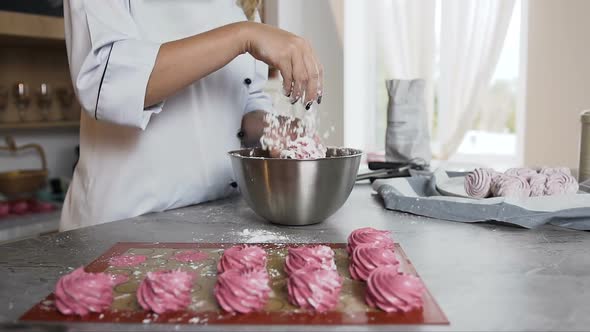 Female Chef Decorating Marshmallow Using Powdered Sugar in the Stylish Kitchen