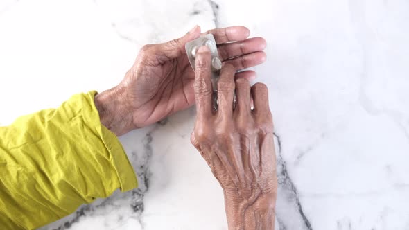 Elderly Women Taking Medicine From Blister Pack