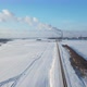 snow-covered road on the background of a factory with smoking pipes top view. - VideoHive Item for Sale