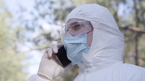 Close-up Side View of Young Caucasian Man in Safety Suit, Protective Eyeglasses and Face Mask