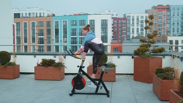 Woman Performs Aerobic Endurance Training Workout Cardio Routine on the Simulators Cycle Training