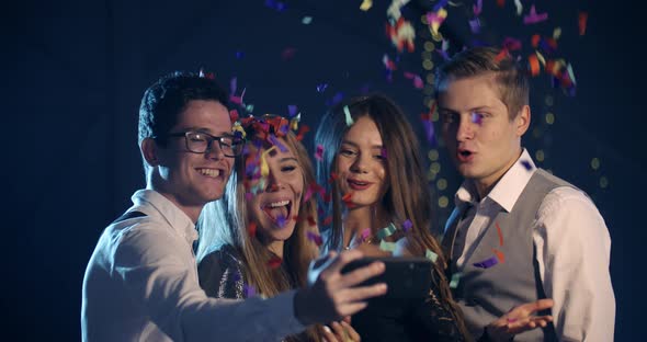 a Group of Young People Smiling and Throwing Confetti Taking Selfies for the New Year Christmas