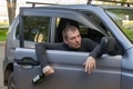 Drunk driver with a bottle of alcohol falls out of the door of his own car - PhotoDune Item for Sale